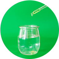 Jojoba Oil: Golden jojoba oil drops falling from a dropper into a clear glass jar with water, highlighting natural moisturizing benefits for bath products.