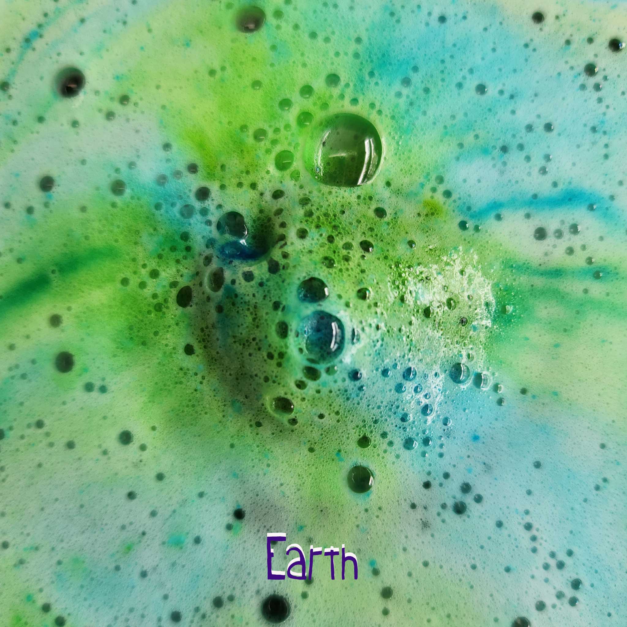 Earth Galaxy Bomb dissolving in water, creating colourful swirls of green and blue.