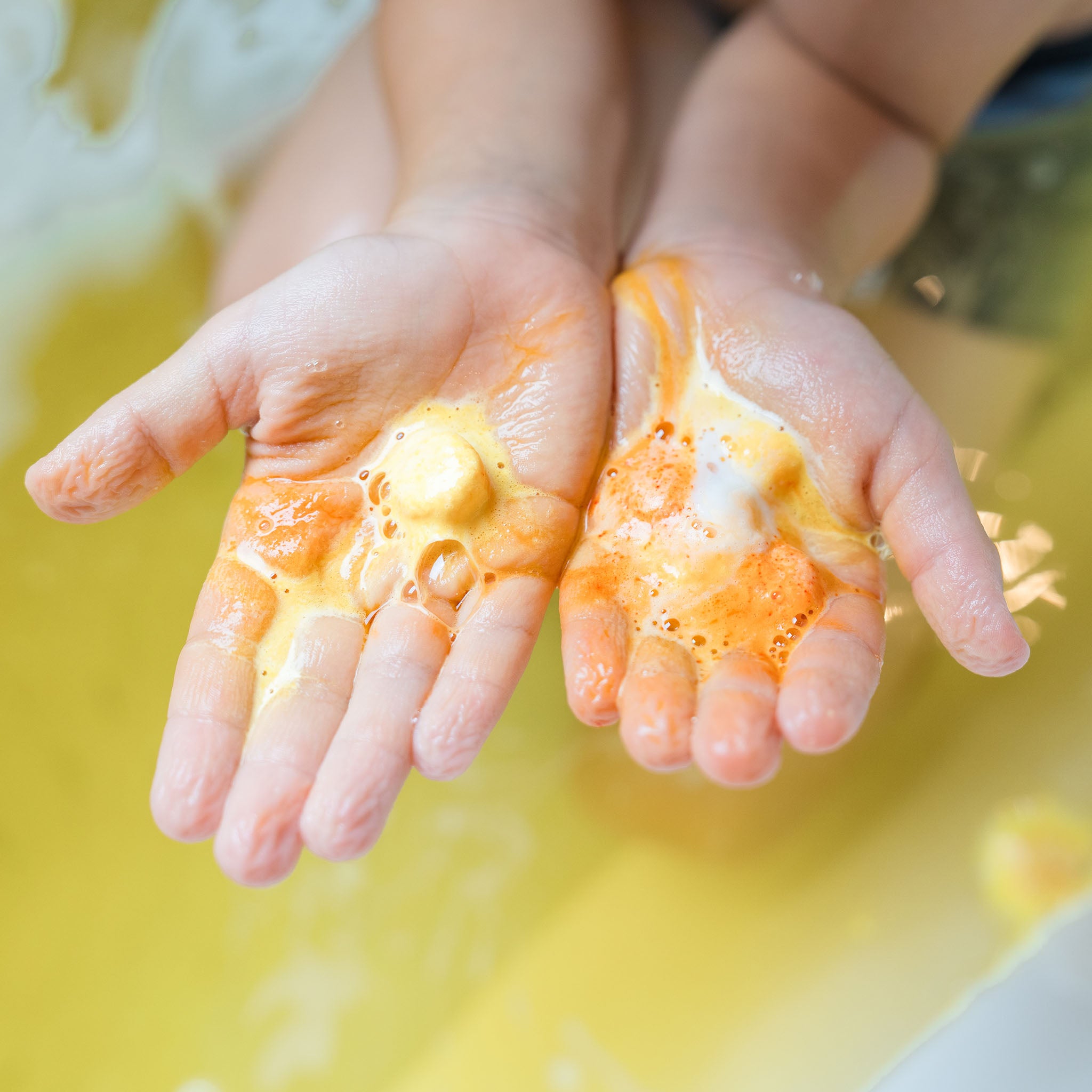 kid hands holding foaming bath salts